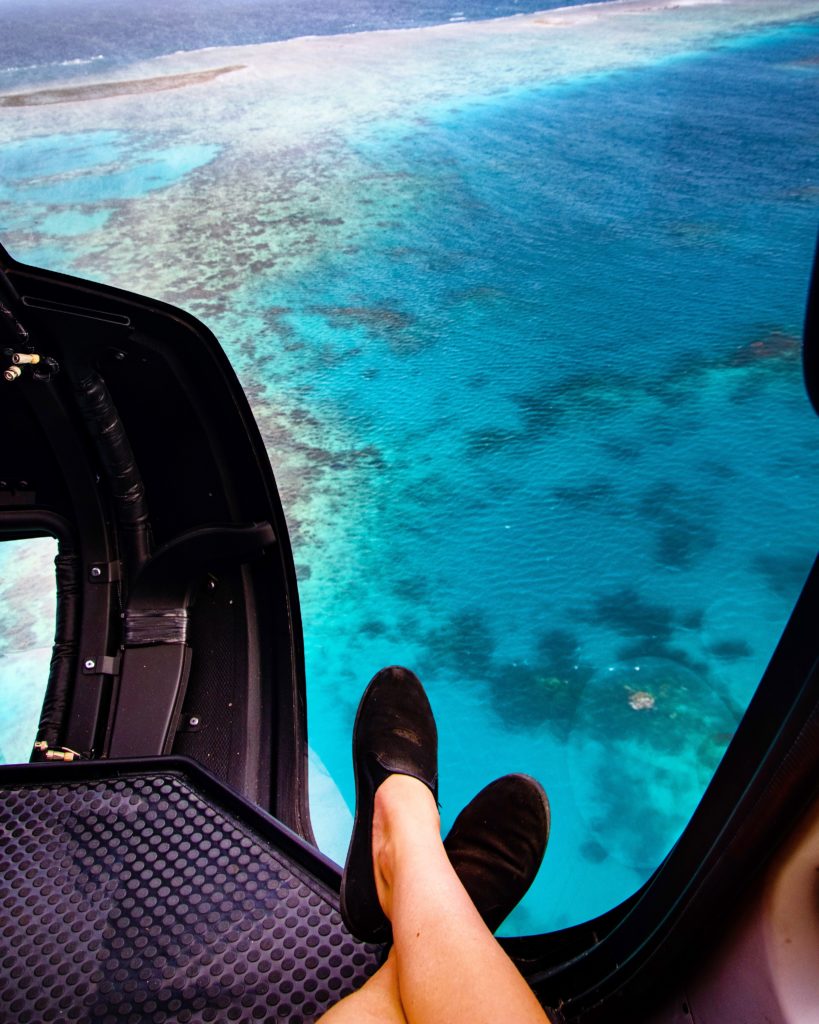 feet in helicopter overlooking the Great Barrier Reef