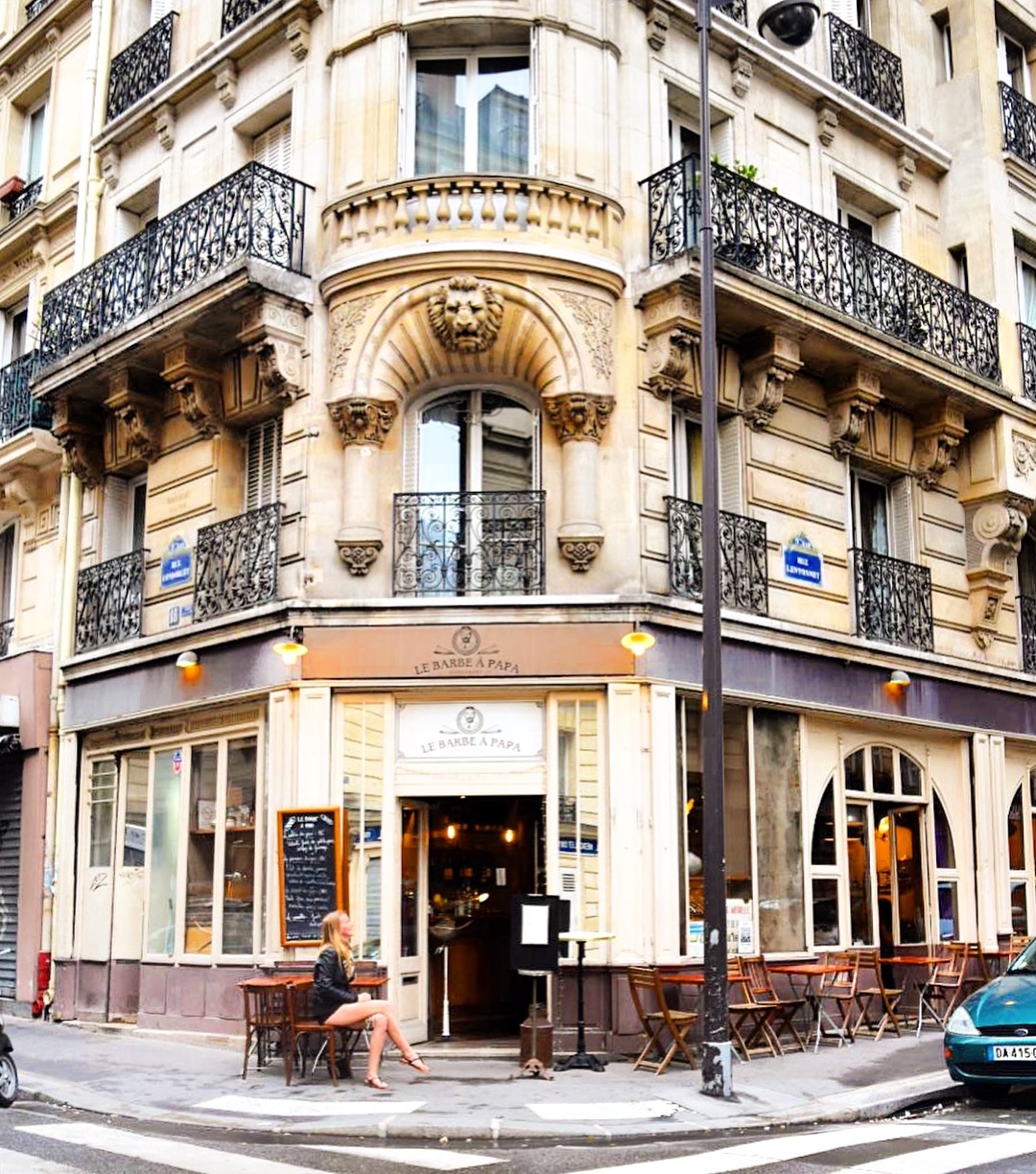 Girl sitting on chair and table out the front of Paris restaurant