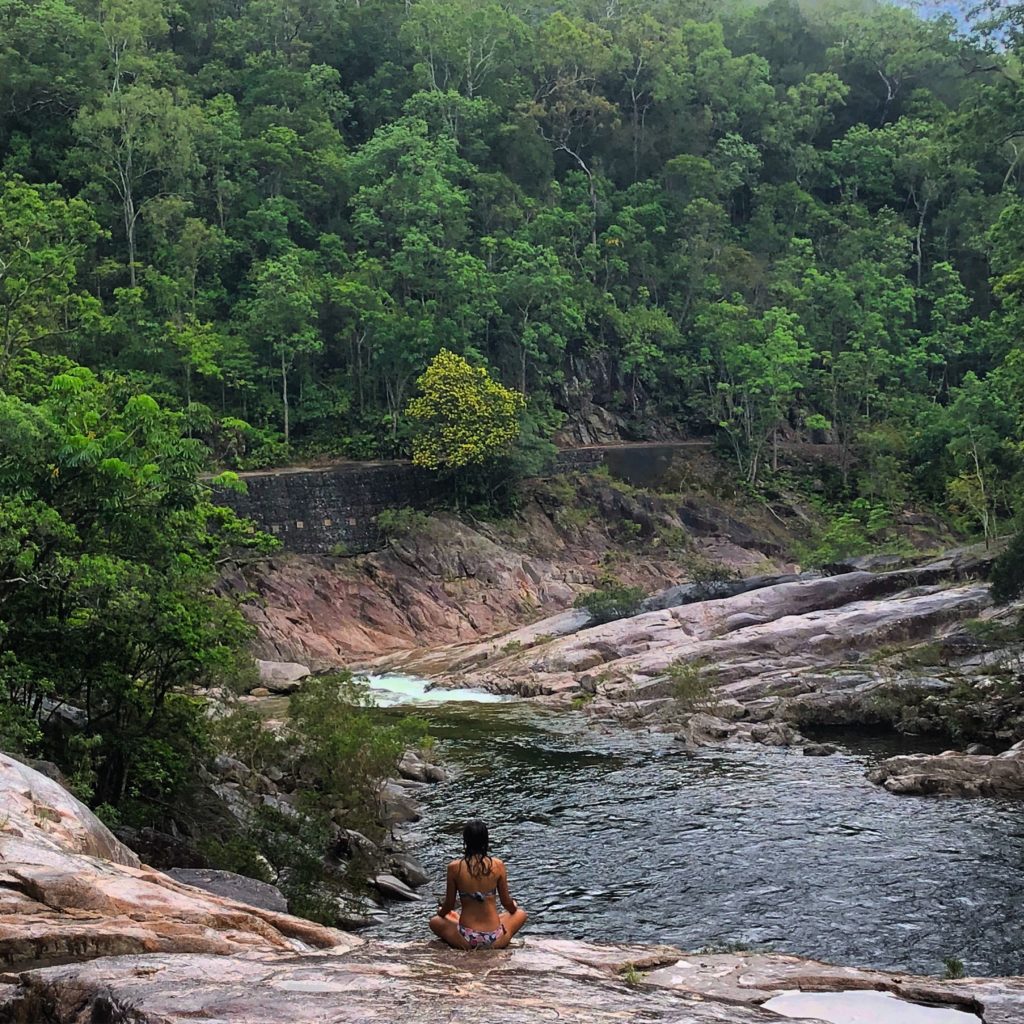 Girl sitting meditating in front of Behana Gorge in Cairns