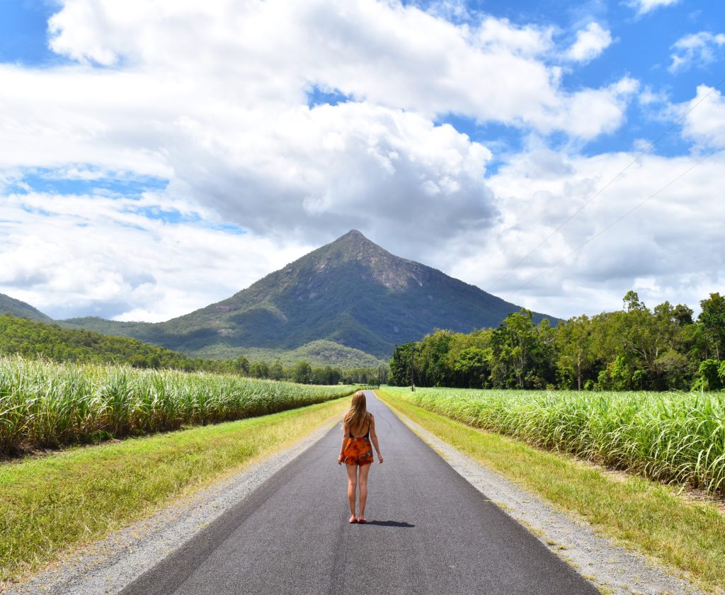 Girl standing on road looking up at Walsh's Pyramid in Cairns