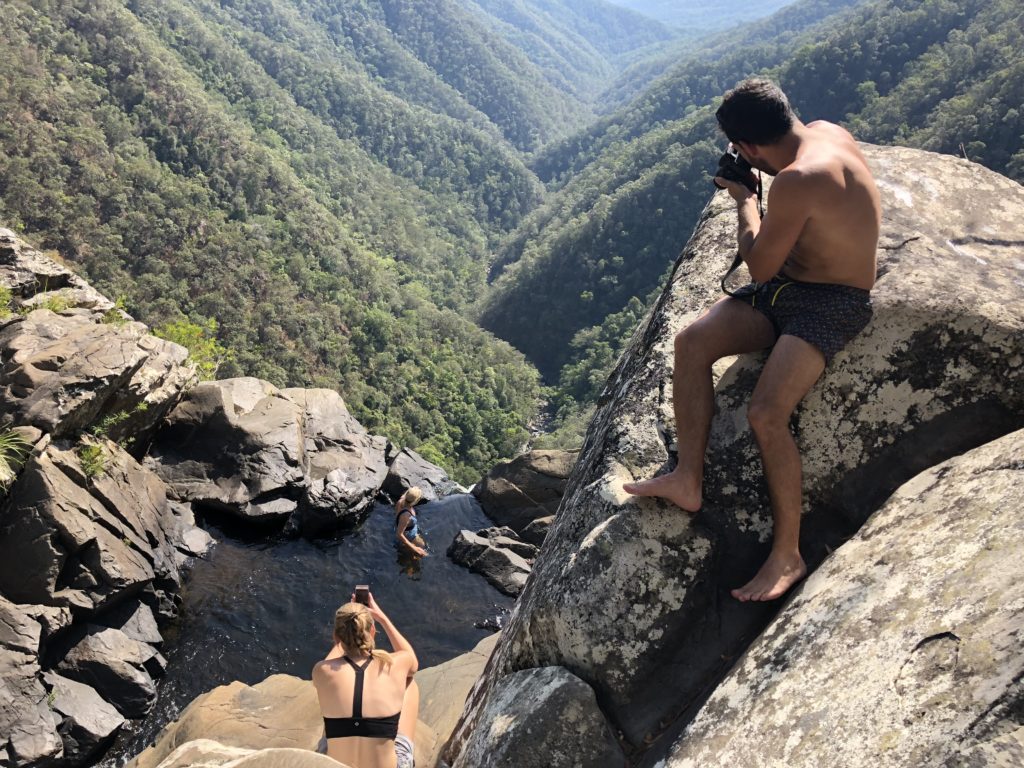 three people taking photos of each other at the top of Windin Falls 
