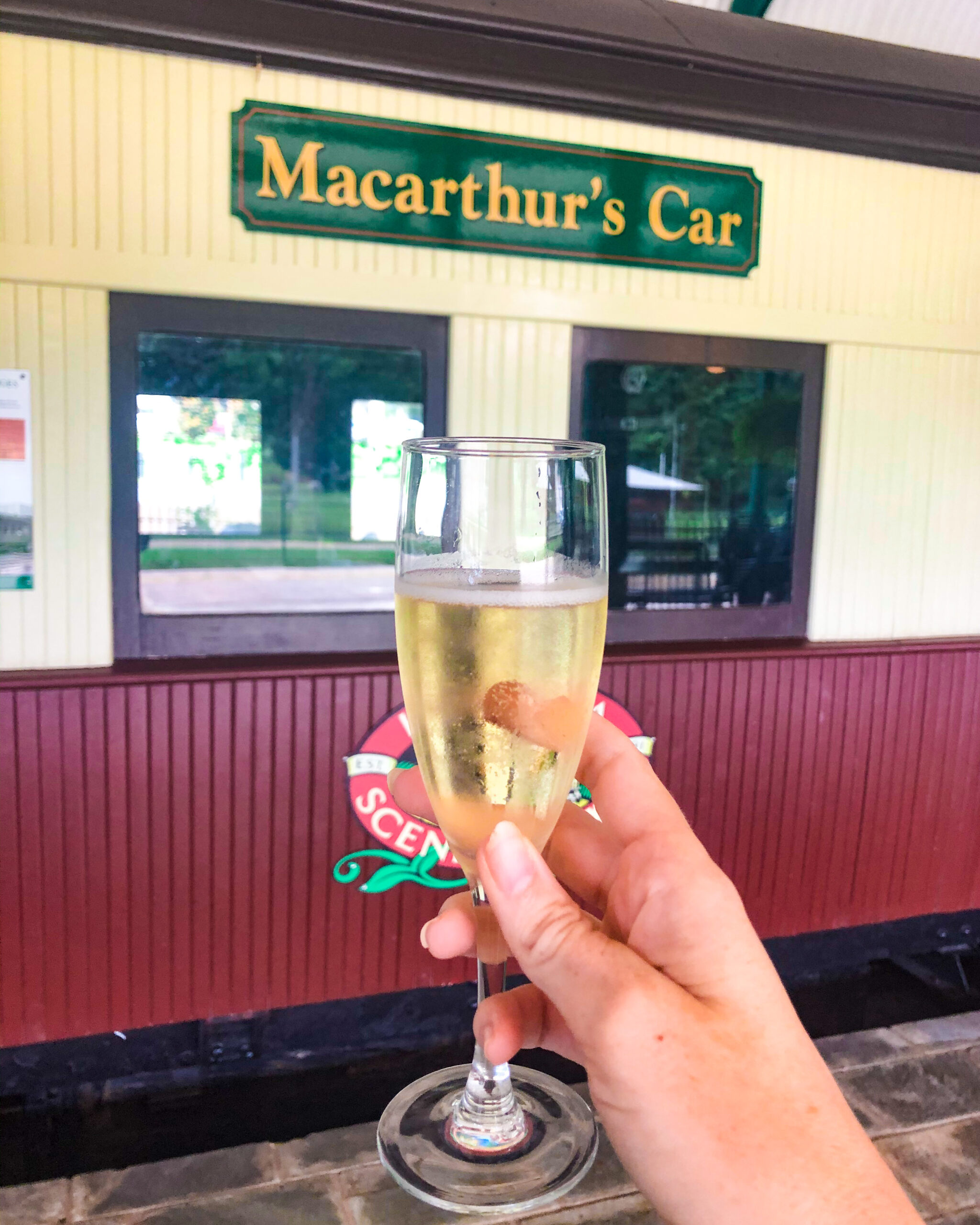 Champagne held in front of railway carriage at High Tea Trolley
